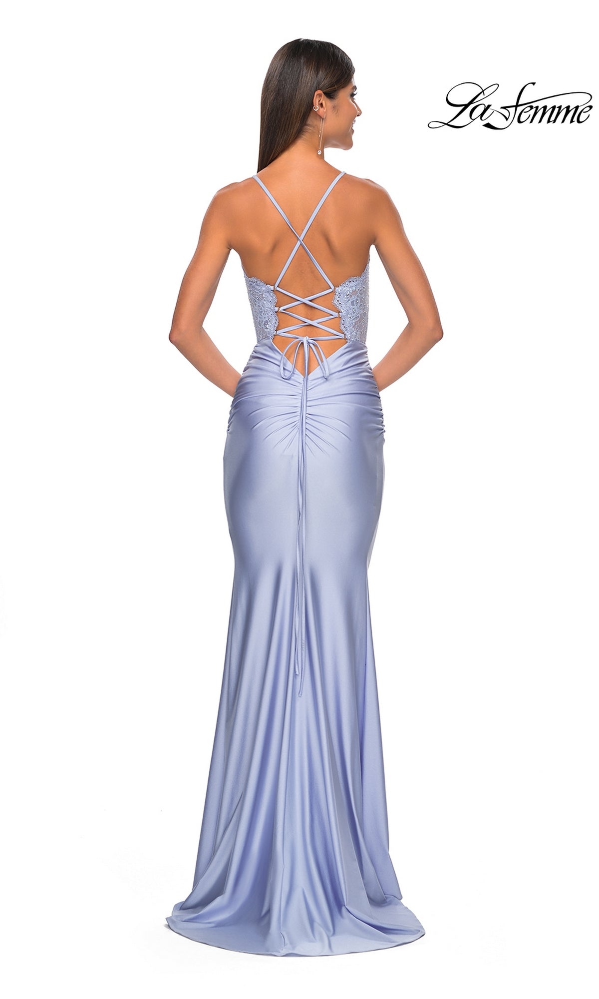 A woman showcases the fitted silhouette and elegant long train of the La Femme Sheer-Corset Tight Long Prom Dress 31272, in lavender satin with an embroidered lace bodice, lace-up open back, and crisscross straps.